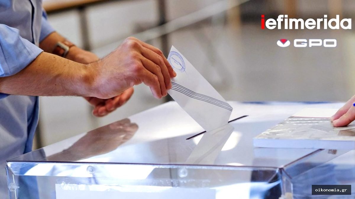 Χέρι ψηφοφόρου τοποθετεί λευκό ψηφοδέλτιο σε διαφανή κάλπη.