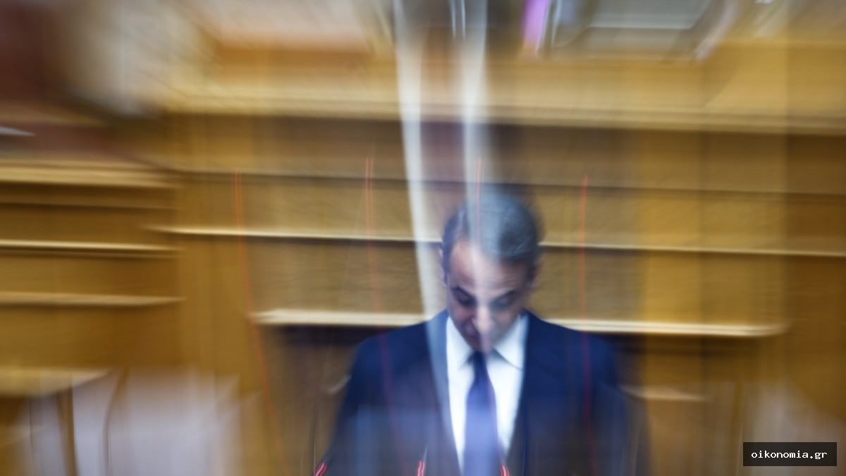 Ο Κυριάκος Μητσοτάκης, με κοστούμι, σε αίθουσα της Βουλής· η εικόνα έχει εφέ θόλωσης κίνησης.