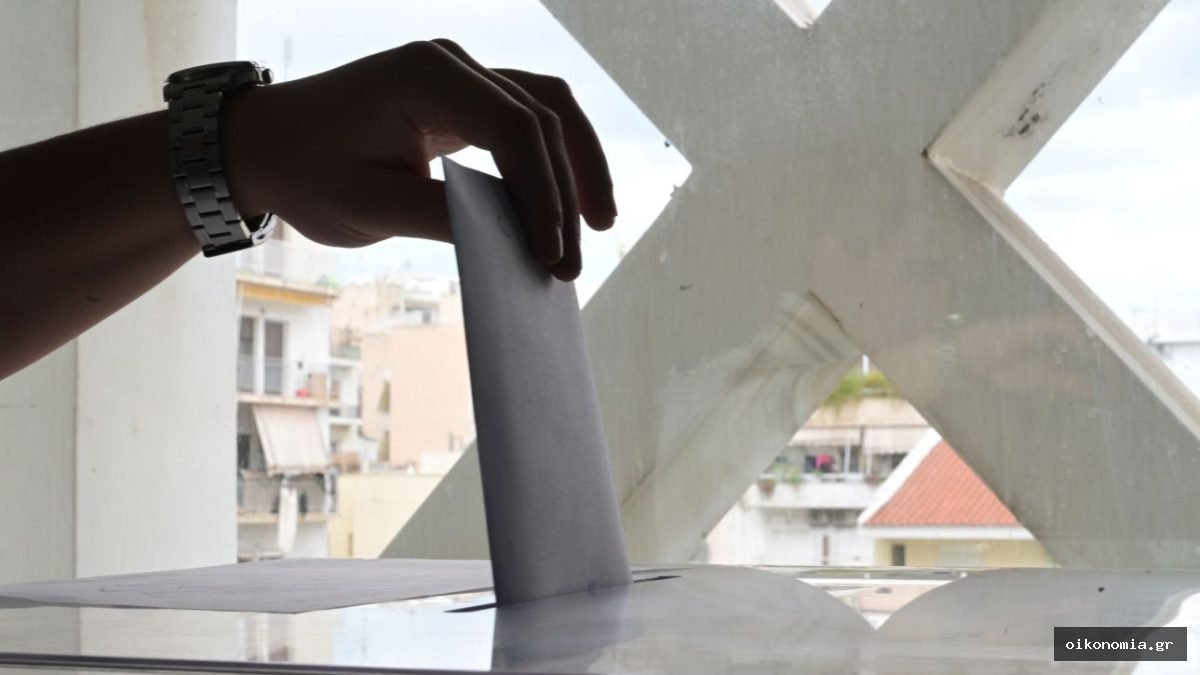 Χέρι τοποθετεί ψηφοδέλτιο σε κάλπη.