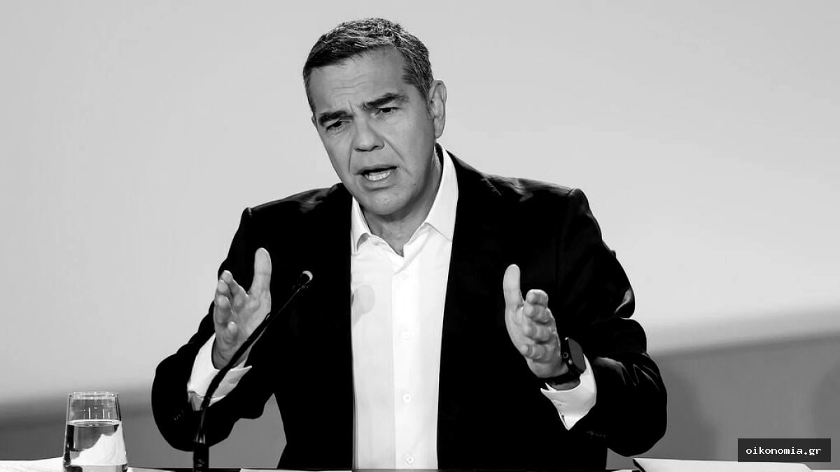 Ο Αλέξης Τσίπρας μιλά σε μικρόφωνο, με τα χέρια υψωμένα μπροστά του.