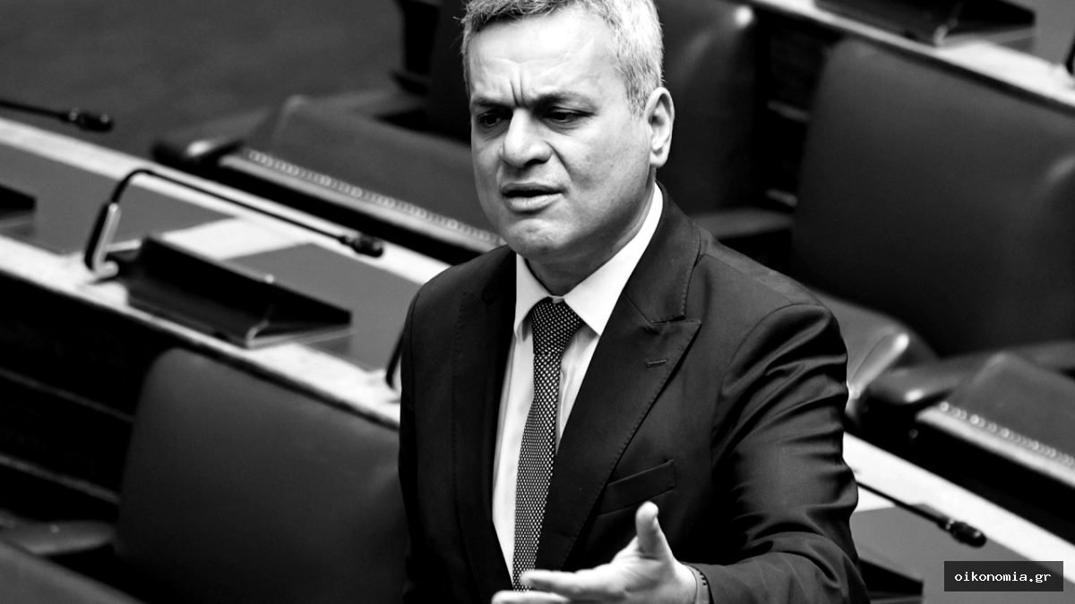 Ο Χάρης Μαμουλάκης, με σκούρο κοστούμι και γραβάτα, μιλά από το βήμα της Βουλής.
