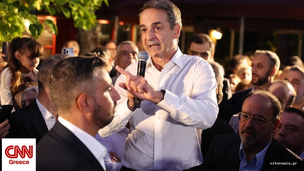 Ο Κυριάκος Μητσοτάκης μιλά με μικρόφωνο σε συγκεντρωμένους σε υπαίθριο χώρο.