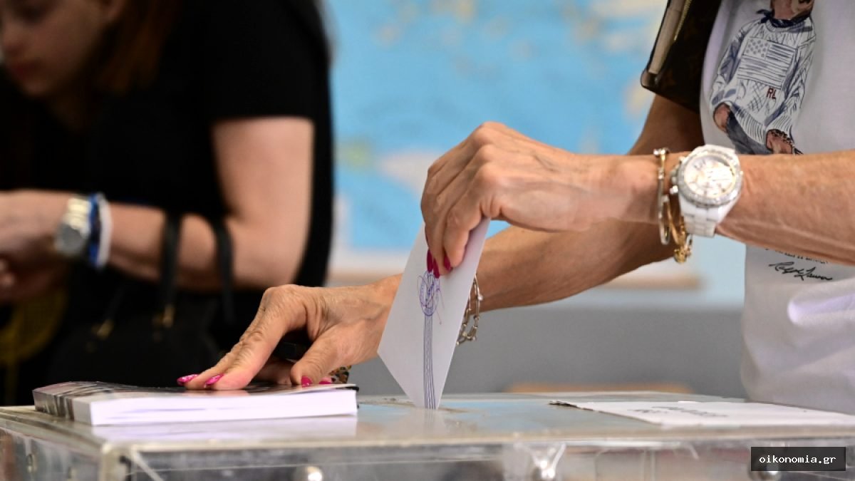 Χέρι ψηφοφόρου ρίχνει ψηφοδέλτιο σε διαφανή κάλπη