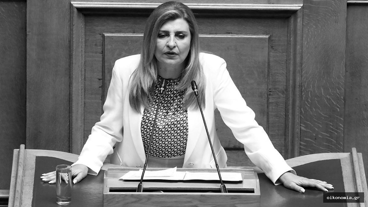 Η Ευαγγελία Λιακούλη μιλά από το βήμα της Βουλής, μπροστά σε ξύλινο έδρανο.