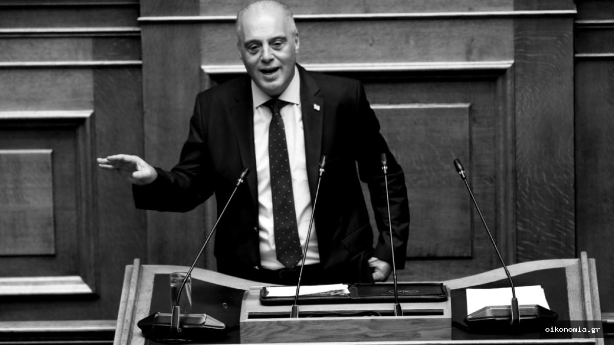 Ο Κυριάκος Βελόπουλος μιλά από το βήμα της Βουλής, με το ένα χέρι απλωμένο.